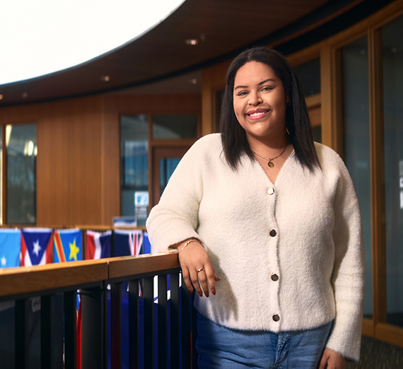 Mujer con una camiseta con una estrella se apoya en una barandilla